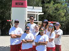 Lifeguards standing with a rescue board