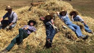 People lounging on a haystack at Ardenwood