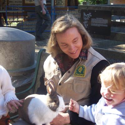 Volunteer Docent with rabbit and two smiling children