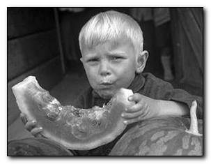 Black and white photo of boy with watermelon